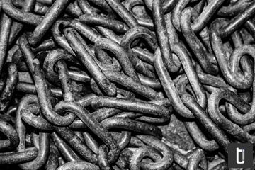 A dense tangle of metal chains photographed in black and white.