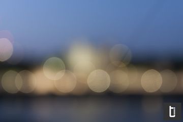 Out-of-focus city lights forming soft circles against blue evening light.